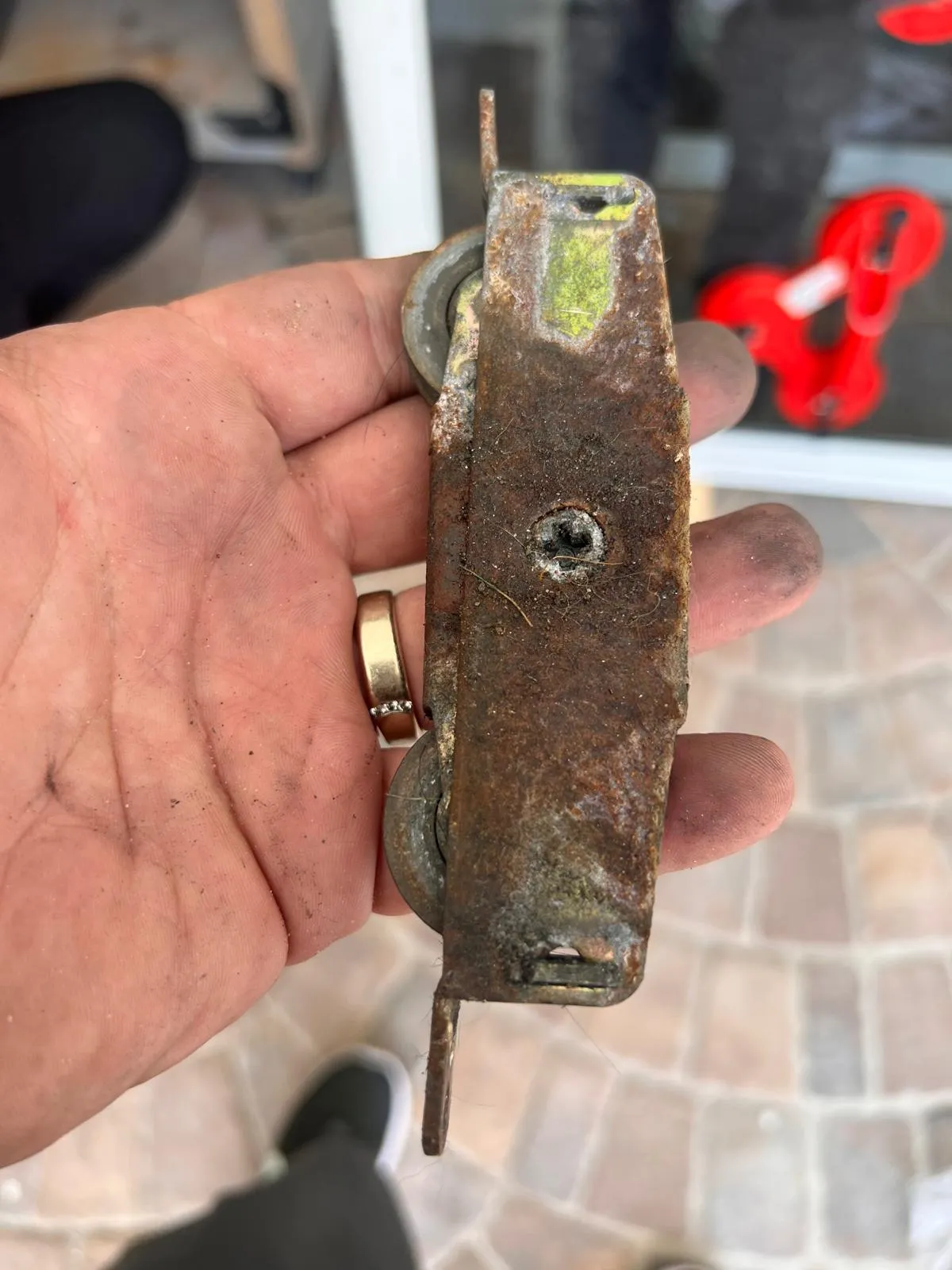 Rusted sliding door rollers removed during a Broward County repair